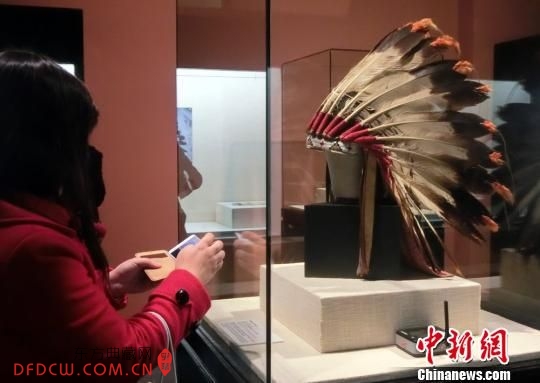 观众欣赏北美洲原住民头戴的鹰羽冠。